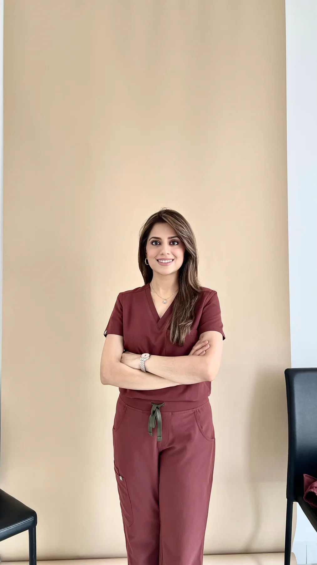 Dr. Fiza Quadri, orthodontist in Kuwait, wearing maroon scrubs