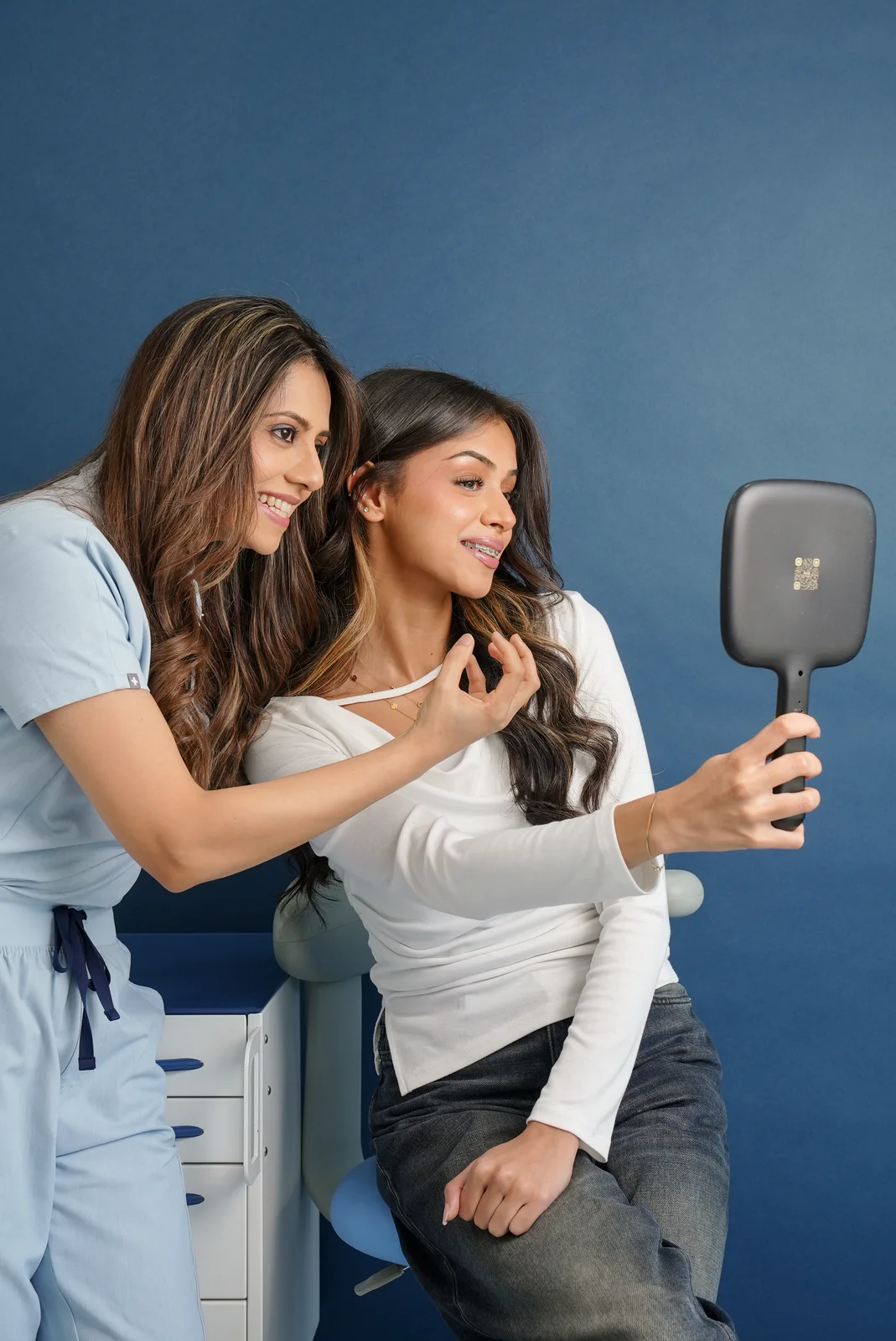 Dr. Fiza Quadri reviewing a teenage patient’s smile during an orthodontic visit